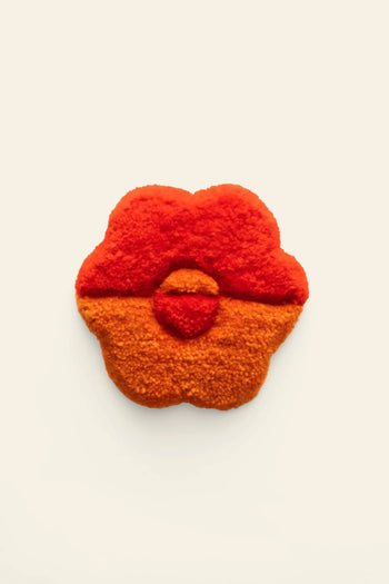The Habichl Tufted Coasters by Habichl feature a unique, abstract flower shape with a red top and orange bottom, showcasing their distinctive tufted design against a plain beige background.