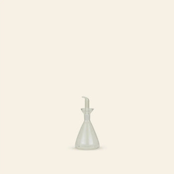 The Hawkins New York Essential Kitchen Bottle, Medium, with modern styling and a precision drizzle spout, sits centered on a light beige background—minimalistic and refined for controlled pouring in any contemporary kitchen.