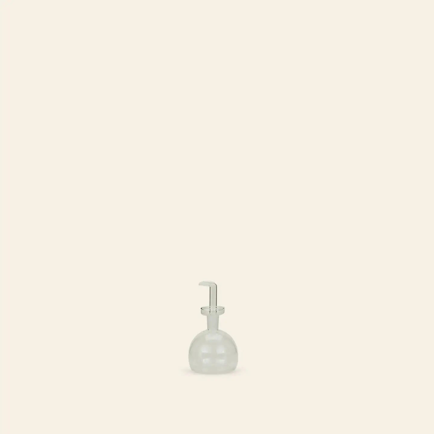 The Hawkins New York Essential Kitchen Bottle, Small, featuring modern styling and a pump, sits near the bottom center of a plain beige background with ample empty space around it.