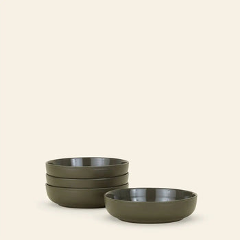 A set of four Hawkins New York Essential Low Bowls is stacked on the left, with another matching bowl in front and to the right, all against a plain beige background—ideal for elevating any dining setting.
