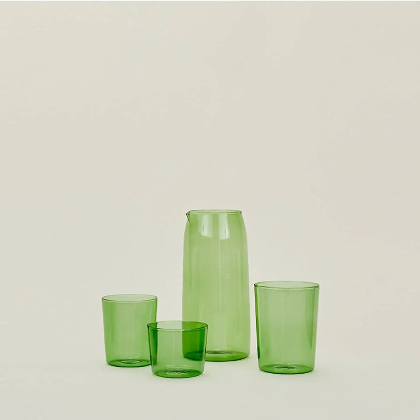 The Hawkins New York Essential Pitcher set features a translucent green pitcher and three cups of different heights, all by Hawkins New York, displayed against a simple light background.