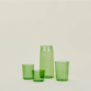 The Hawkins New York Essential Pitcher set features a translucent green pitcher and three cups of different heights, all by Hawkins New York, displayed against a simple light background.