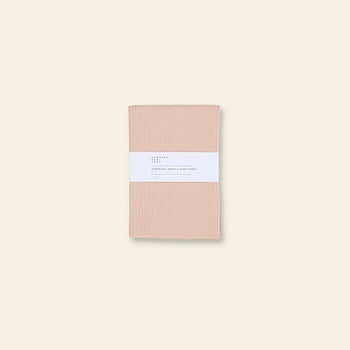 A set of two light beige Hawkins New York Essential Waffle Dish Towels is centered on a neutral background, wrapped in a white label.