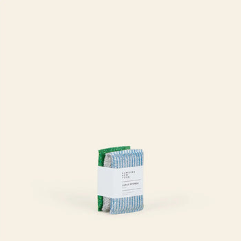 The Hawkins New York Lurex Sponges, Set of 3 features green, silver Lurex, and blue rectangular sponges stacked with a white label against a beige background.