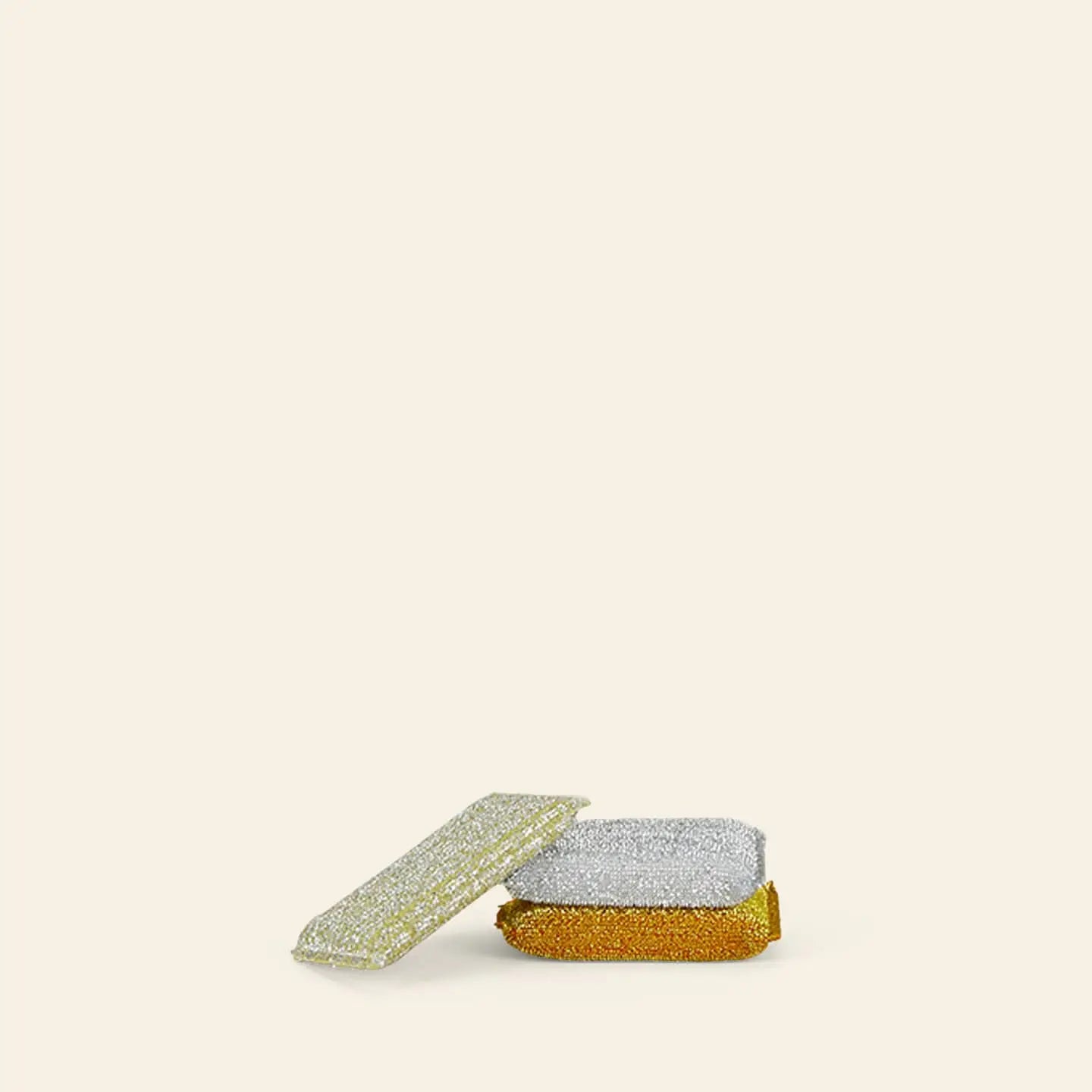 The Hawkins New York Lurex Sponges, Set of 3, includes gold, silver, and silver-and-gold sponges that bring a sparkling touch to your kitchen; all are stacked on a plain, light-colored background.