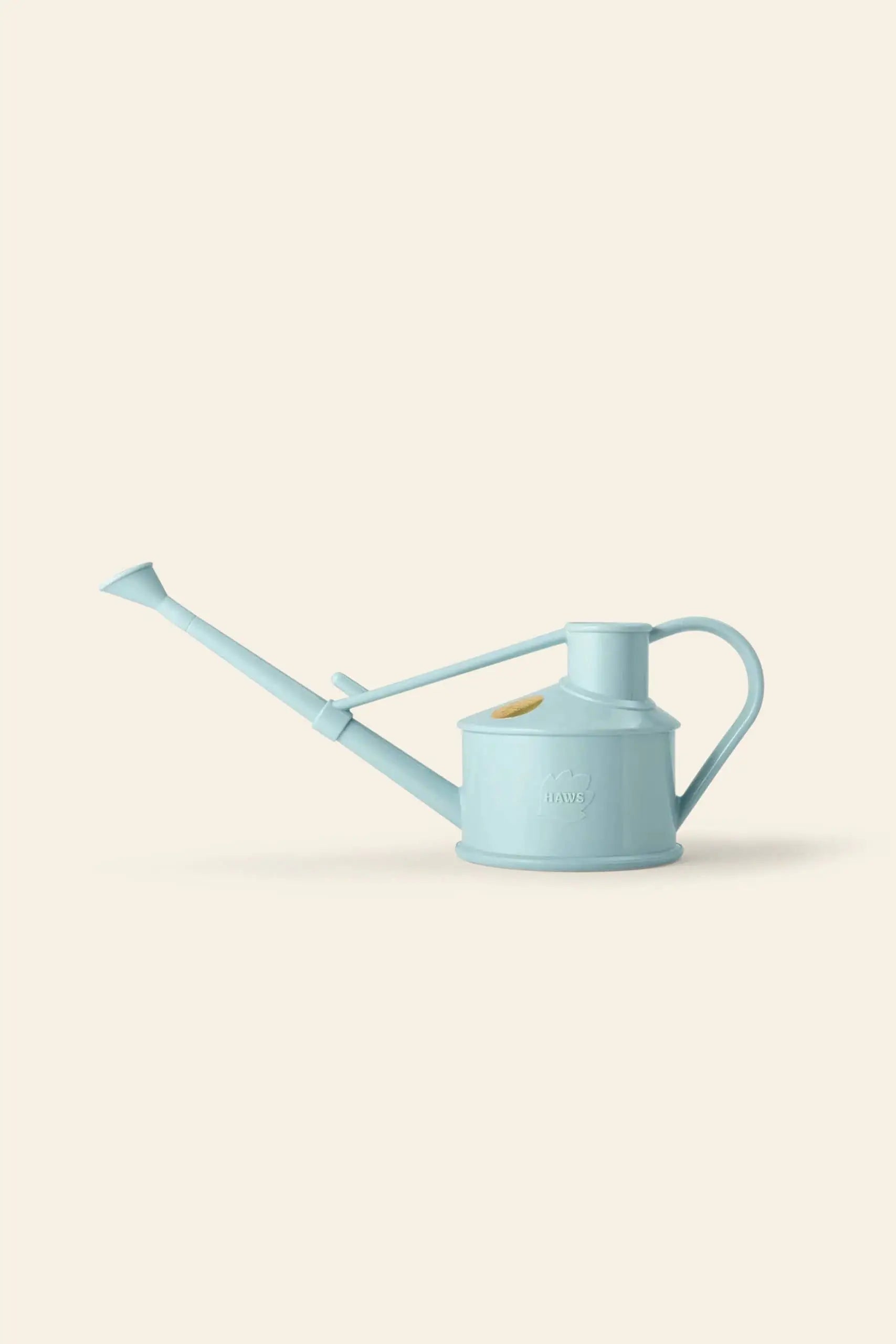 The Haws The Langley Sprinkler by Haws is a light blue watering can made from recyclable plastic, featuring a long spout and large handle for optimal water coverage, shown on a plain beige background.