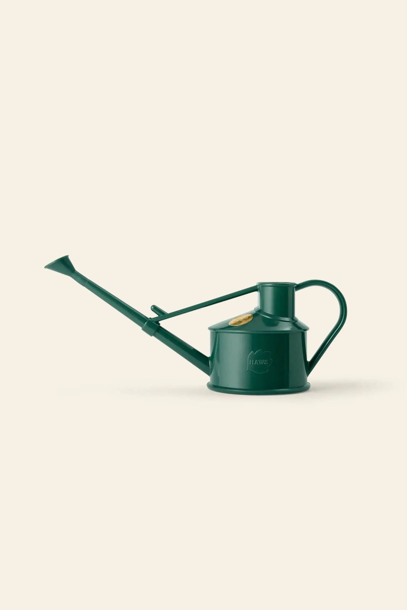 The Haws The Langley Sprinkler by Haws is a dark green watering can made from recyclable plastic, featuring a long spout and rounded handle for efficient watering, shown on a plain light beige background.