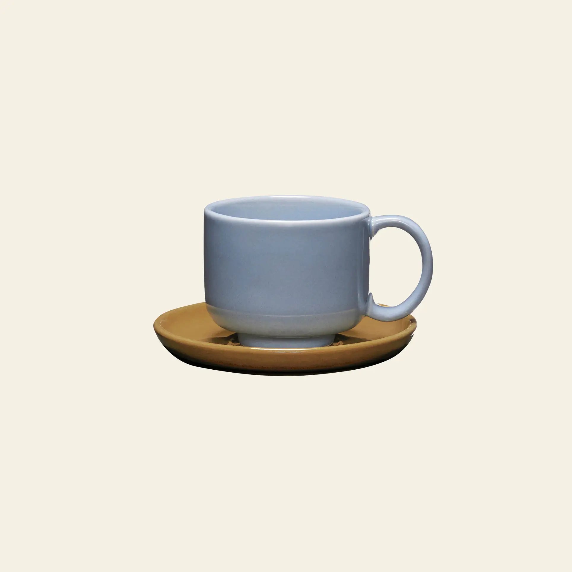 The Hübsch Amare Cup With Saucer by Hübsch features a retro-inspired light blue ceramic cup paired with a round brown saucer, set against a plain light beige background.