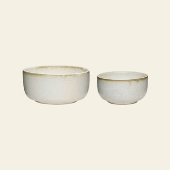 Two Hübsch Clay Bowls of different sizes sit side by side on a plain background. This set of 2 from Hübsch features a simple, rounded shape and an elegant beige and gray speckled finish.