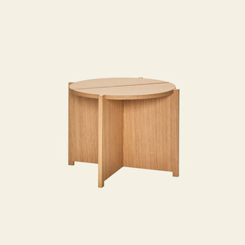 The Hübsch Dash Side Table by Hübsch is crafted from FSC-certified wood, featuring a smooth round top and intersecting vertical panel legs in a minimalist design, set against a plain off-white background.