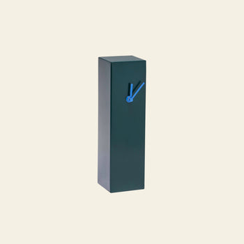 The Hübsch Hour Clock by Hübsch is a tall, rectangular, dark green timepiece with minimal design and blue hands, showcased against a plain light beige background to highlight its unique clock design.