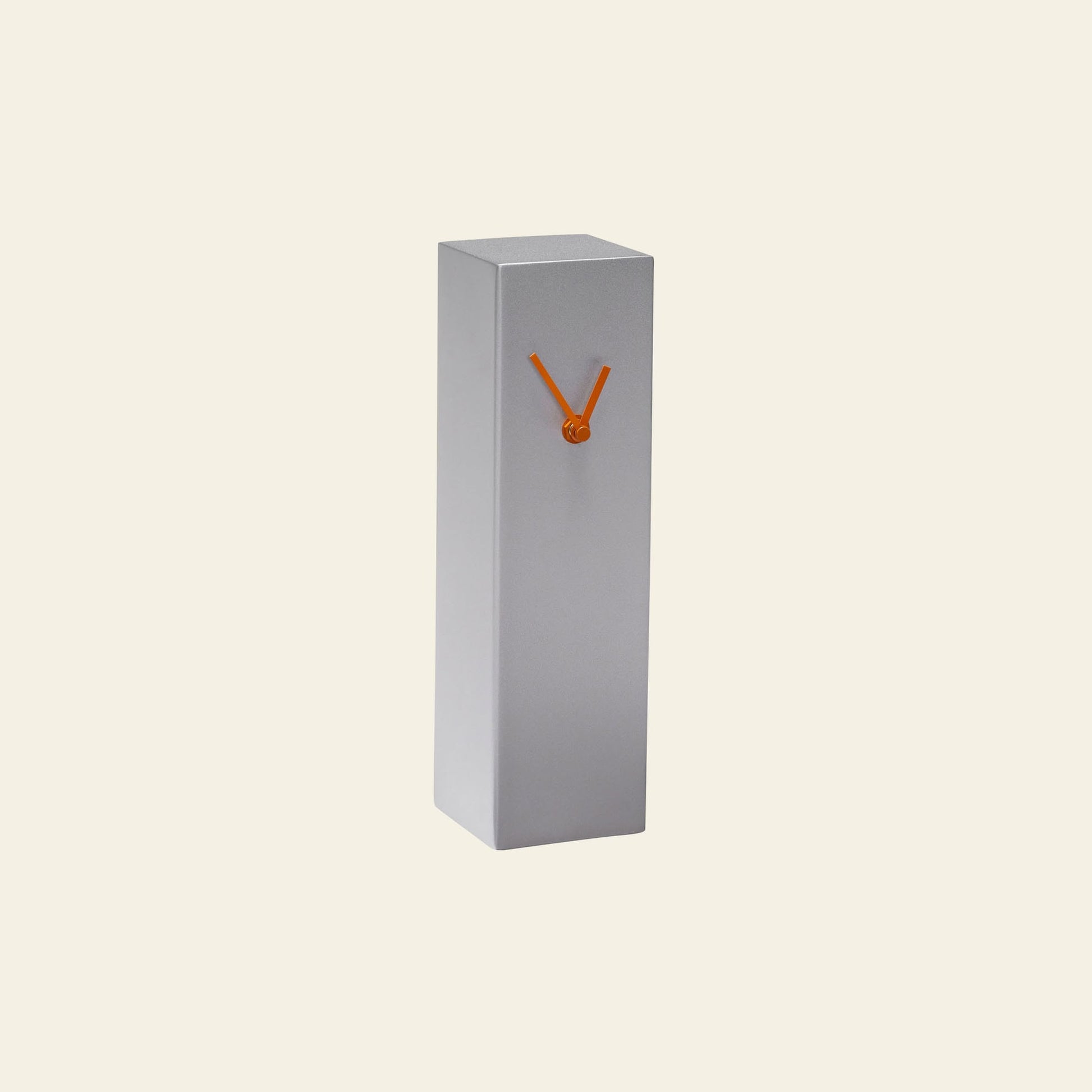 The Hübsch Hour Clock by Hübsch is a minimalist, rectangular gray timepiece with two orange hands forming a V shape on its front, highlighting its unique design against a plain light background.