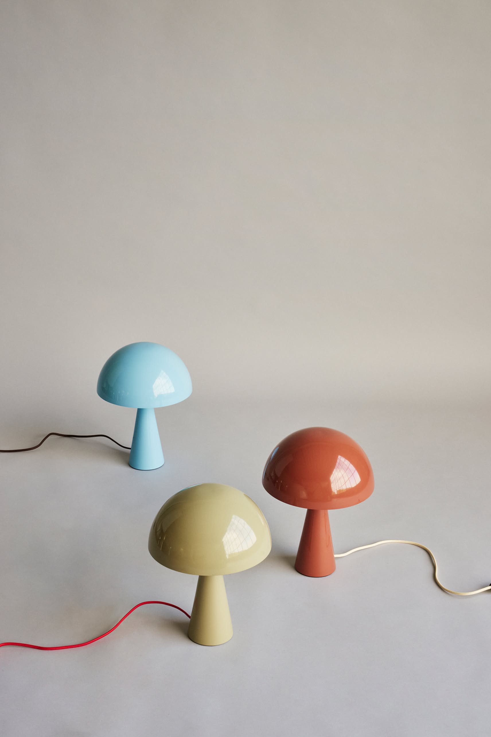 The Hübsch Mush Table Lamp Mini by Hübsch is available in pastel blue, pale yellow, and terracotta, each with a coordinating cord—ideal for adding charm to any modern home with a light, neutral background.