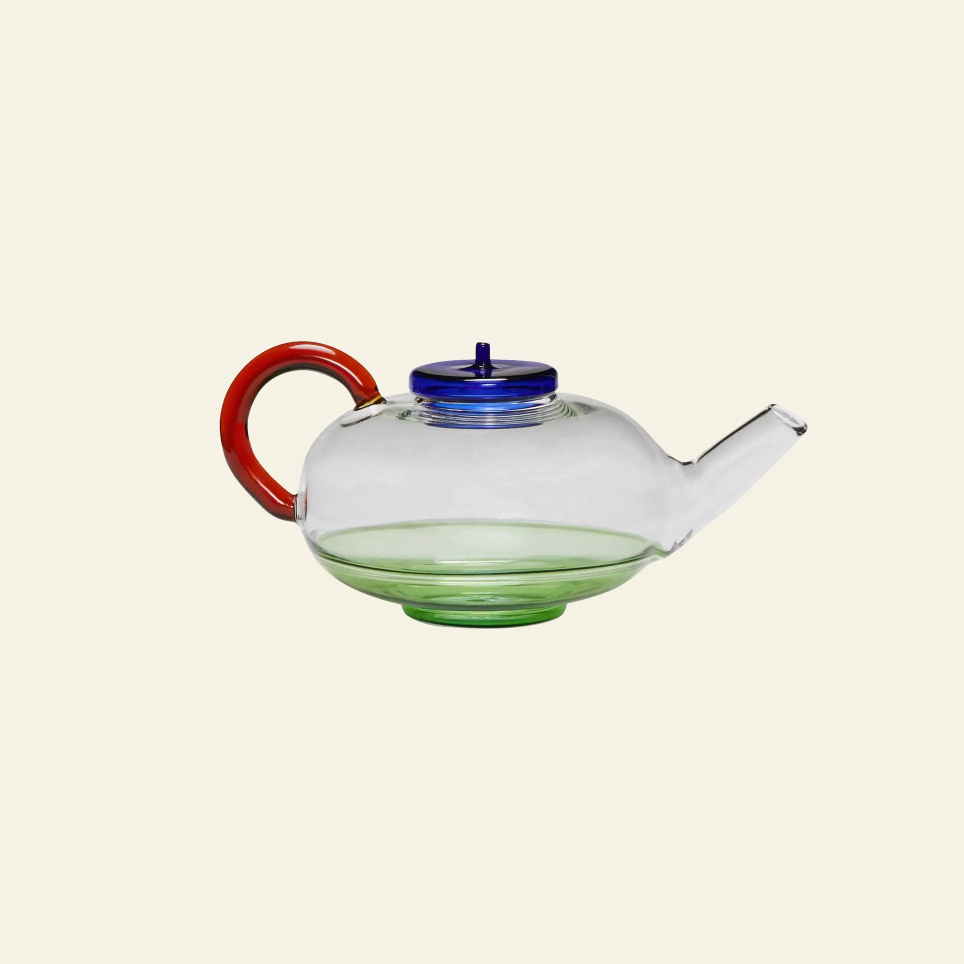 The Hübsch Norush Teapot by Hübsch, with its clear glass body, blue lid, red handle, and green base, adds a cheerful pop of color to tea gatherings against a plain light background.