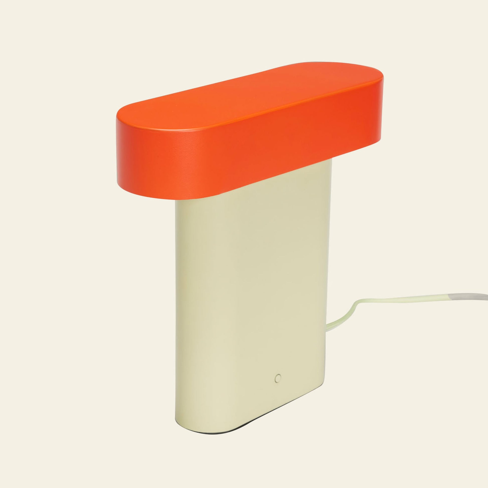 The Hübsch Sleek Table Lamp by Hübsch features a beige rectangular base, an oval bright orange top, and modern minimalistic design. It includes a convenient dimmable function and has a power cord extending from the back.