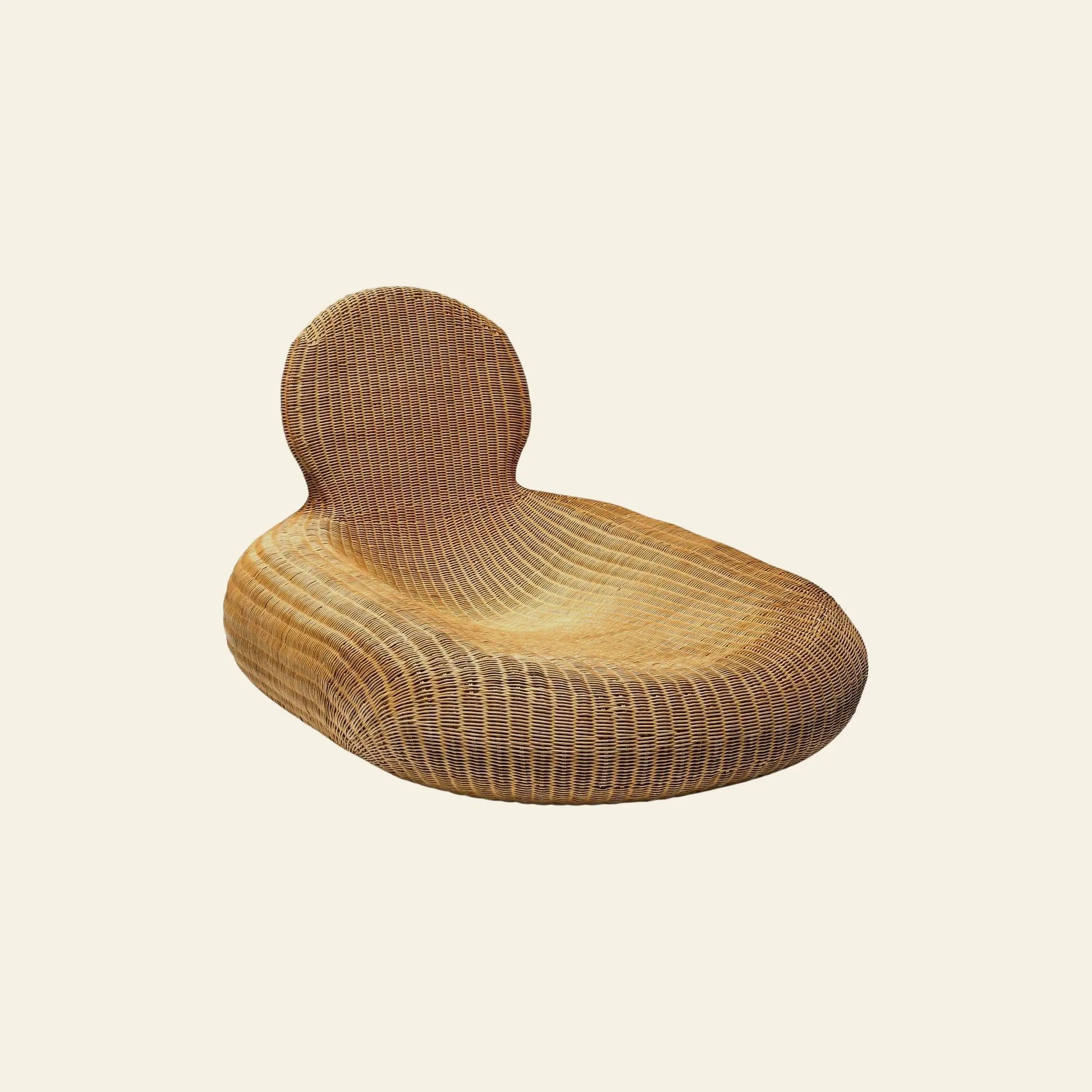 The IKEA Rattan Storvik Lounge Chair by IKEA features a rounded backrest and low, wide seat, offering contemporary comfort and timeless style against a light beige backdrop.