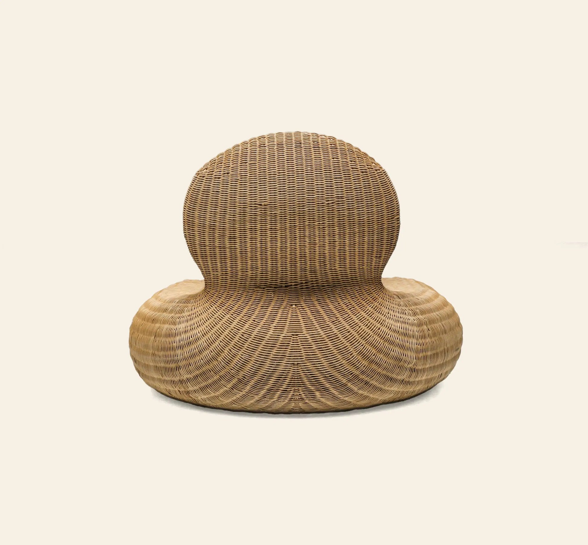 The IKEA Rattan Storvik Lounge Chair by IKEA features a sculptural, modern design with woven rattan, a round backrest, and a wide curved seat, inspired by vintage lounge chairs and set against an off-white background.