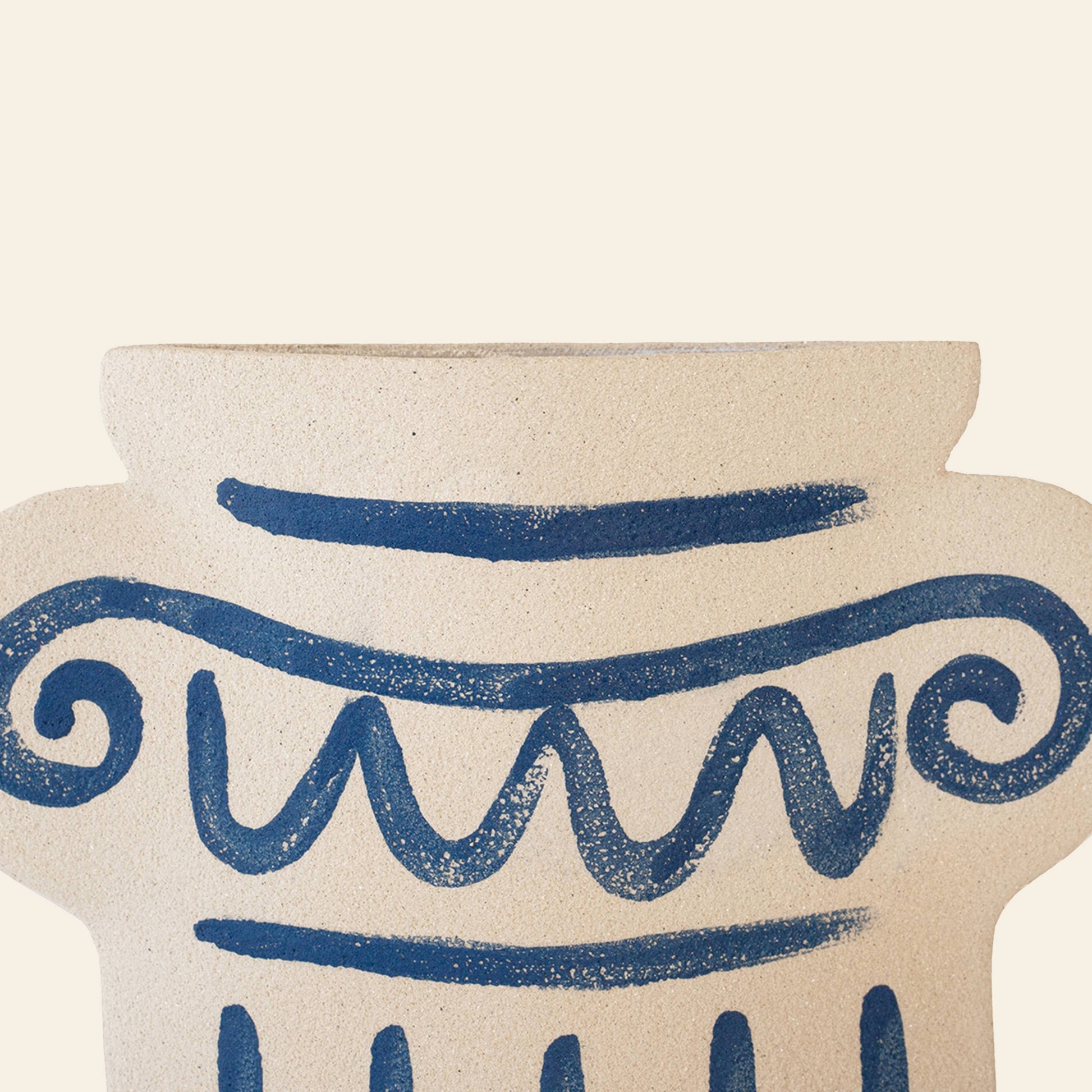 A close-up of the INI CERAMIQUE Greek Column Ceramic Vase in beige, with blue hand-painted swirl and zigzag patterns inspired by ancient Greek pottery, set against a plain light background.