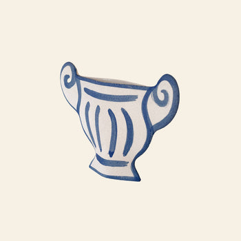 The INI CERAMIQUE Greek Coupe Ceramic Vase features a stylized, hand-drawn white design with blue outlines and swirled handles, reminiscent of ancient Greek pottery, displayed on a plain light background.
