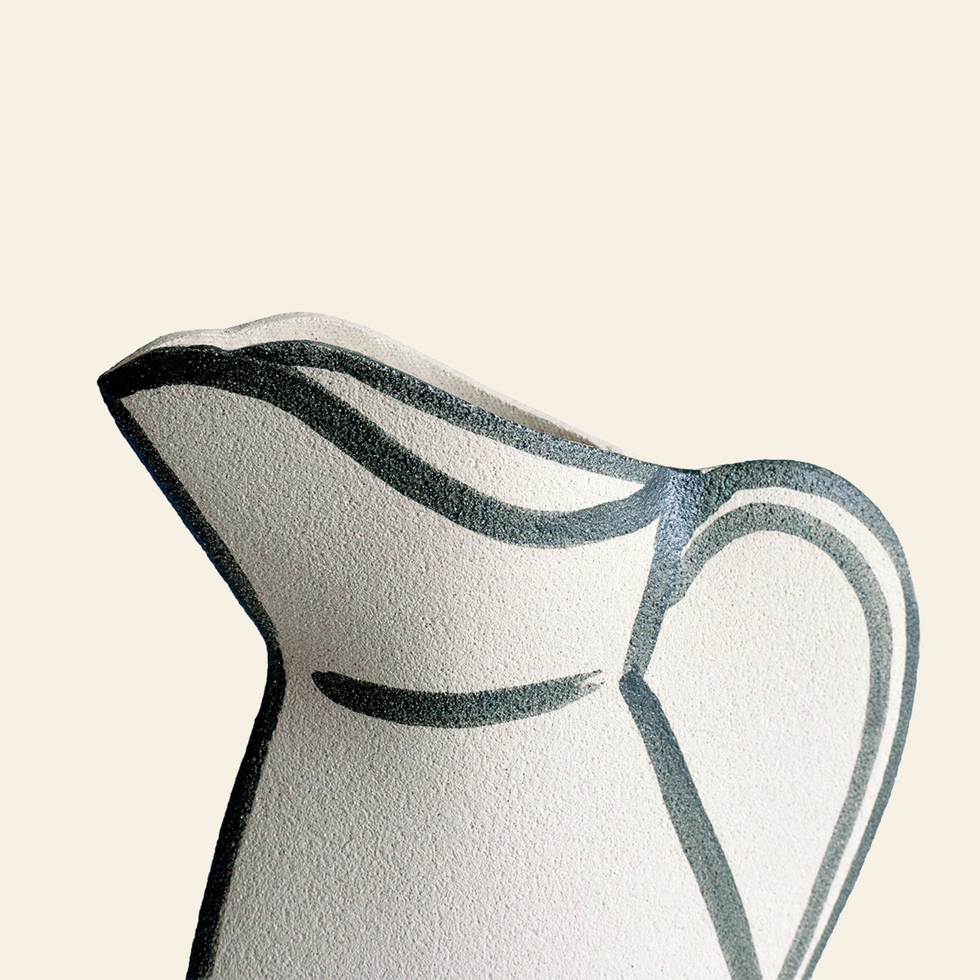 A close-up of the INI CERAMIQUE Morandi Pitcher Ceramic Vase, highlighting its artisanal craftsmanship with a textured ceramic finish and minimalist black line design on a light beige background.