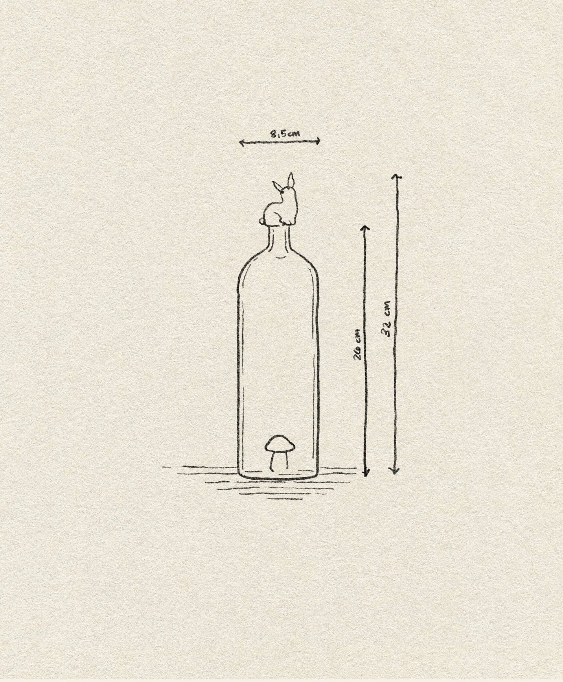 The Ichendorf Milano Alice Bottle by Ichendorf Milano features a simple line design of a tall, 20 cm bottle with a small colorful mushroom inside and a rabbit on top. Total height (with rabbit) is 23.2 cm, width is 9.5 cm—a unique charm for any space.