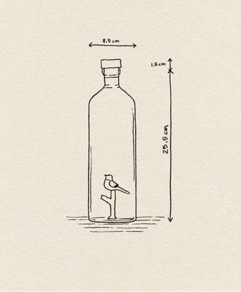 A minimalist line drawing of the Ichendorf Milano Animal Farm Bottle by Ichendorf Milano shows a small bird on one leg inside the glass, labeled 23.5 cm tall and 8.5 cm wide, set against a beige textured background.