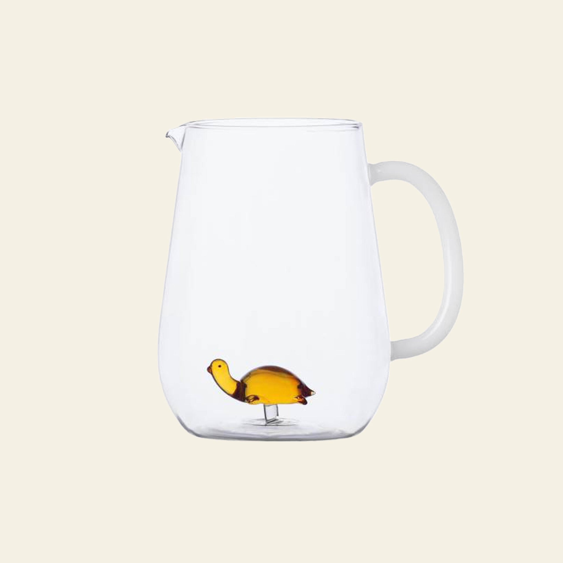 The Ichendorf Milano Animal Farm Pitcher - Amber Turtle is a clear hand-crafted glassware pitcher with a handle, featuring a small amber glass turtle figurine at the bottom. It’s part of the charming Animal Farm collection by Ichendorf Milano.