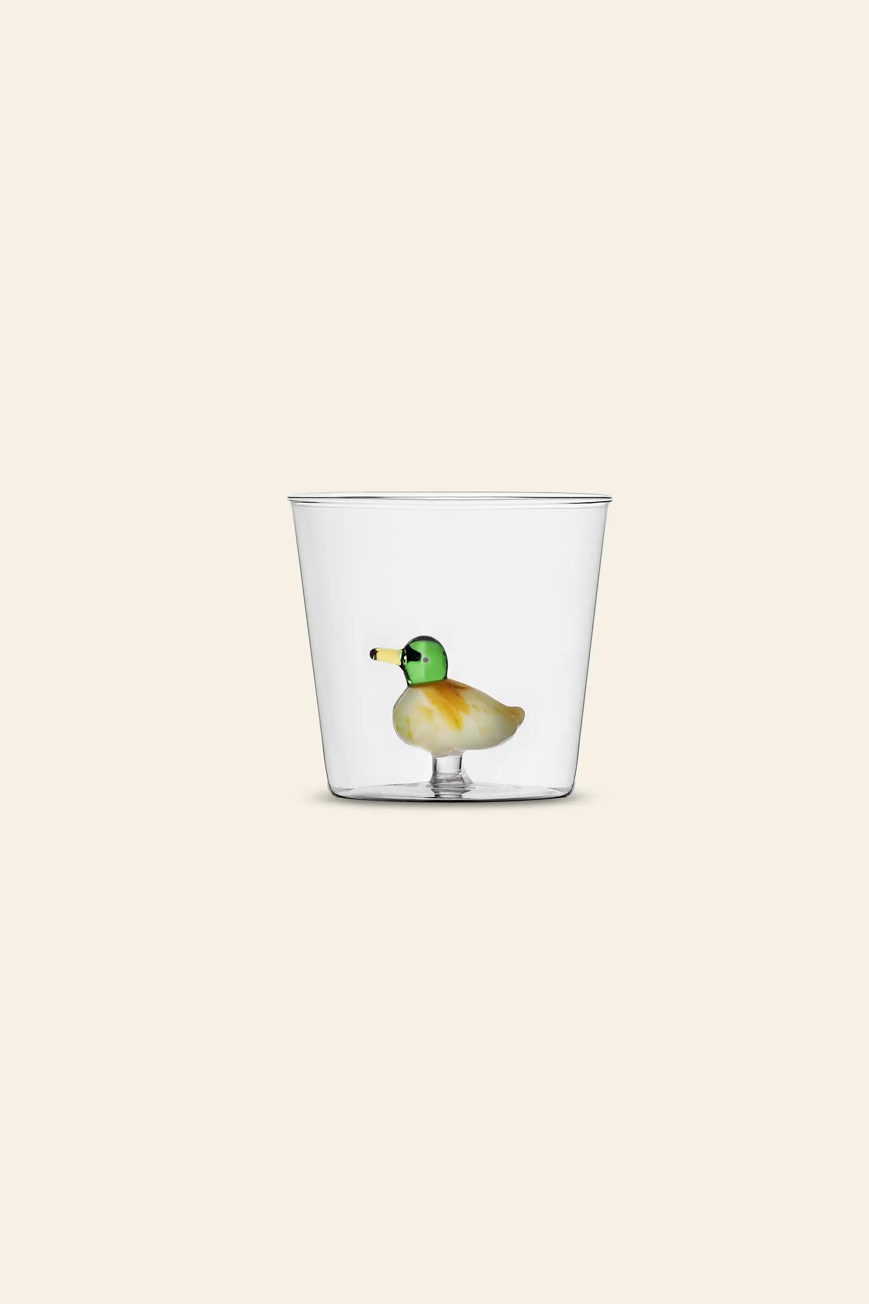 The Ichendorf Milano Animal Farm Tumbler by Ichendorf Milano features a small, colorful glass duck figurine attached to the inside bottom, displayed against a plain beige background.