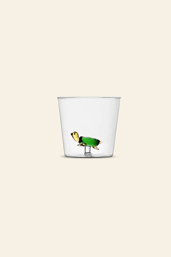 The Ichendorf Milano Animal Farm Tumbler by Ichendorf Milano features a clear glass against a light beige background, with a charming green and yellow turtle figurine attached inside—whimsical glassware at its finest.