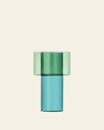 The Ichendorf Milano Boreale Vase A by Ichendorf Milano features modern two-tone borosilicate glass with a wide light green top and tall cylindrical teal blue base—perfect for artistic floral displays against a beige background.
