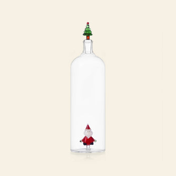 The Ichendorf Milano Christmas Tales Bottle by Ichendorf Milano features clear glass, a small Santa figurine inside, and a decorative tree-shaped stopper, set against a simple light background.