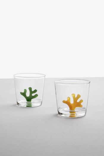 Two Ichendorf Milano Coral Reef Tumblers by Ichendorf Milano, one with green accents and one with yellow, rest on a gray surface against a plain white background, each showcasing vibrant designs inspired by delicate underwater ecosystems.