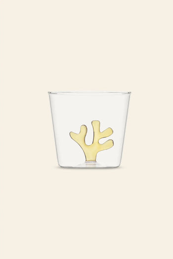 The Ichendorf Milano Coral Reef Tumbler by Ichendorf Milano features a clear glass with a yellow coral-inspired design, set on a light beige background. This elegant piece reflects Alessandra Baldereschi’s love for underwater ecosystems.