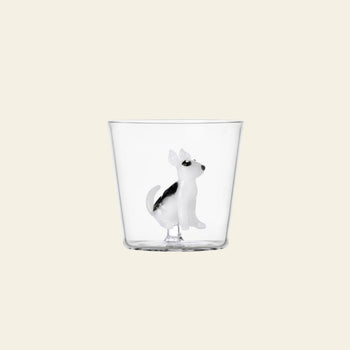 The Ichendorf Milano Dogs Tumbler - Bull Terrier is a clear glass by Ichendorf Milano, featuring a small black and white Bull Terrier figurine inside, set against a plain light beige background.