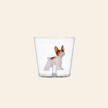 The Ichendorf Milano Dogs Tumbler - French Bulldog is a clear glass tumbler by Ichendorf Milano, featuring a small brown and white French Bulldog figurine attached to the base, ideal for any dog lover’s collection.