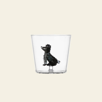 The Ichendorf Milano Dogs Tumbler - Poodle by Ichendorf Milano is a clear glass with a small, detailed black poodle figurine attached inside the base, set against a simple light background.