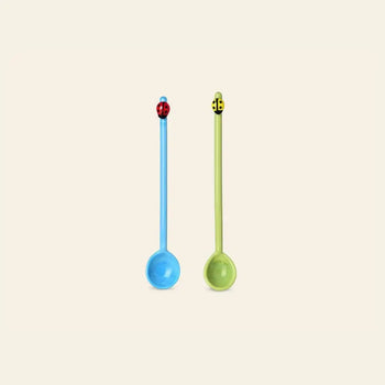 The Ichendorf Milano Fruits and Flower Teaspoons, Set of 2 by Ichendorf Milano features a blue spoon with a red ladybug and a green spoon with a yellow and black bee, both standing upright on a plain light background.