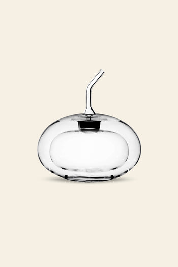 The Ichendorf Milano Sfera Doublewalled Olive Oil Bottle by Ichendorf Milano is a clear, round glass container with a spherical design and short angled spout, shown against a plain beige background.