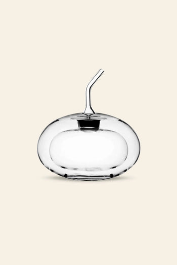 The Ichendorf Milano Sfera Doublewalled Olive Oil Bottle, designed with a clear spherical shape and short angled spout, by Ichendorf Milano, is displayed against a plain light beige background.