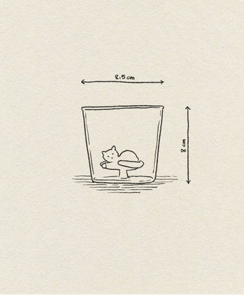 The Ichendorf Milano Tabby Cat Tumbler by Ichendorf Milano features a simple line drawing of a cat curled up inside the glass, which measures 8 cm tall and 2.5 cm wide at the top.