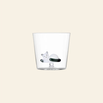 The Ichendorf Milano Tabby Cat Tumbler features a small white glass cat curled up at the bottom—a charming piece from Ichendorf Milano, perfect for cat lovers. Shown against a plain beige background.