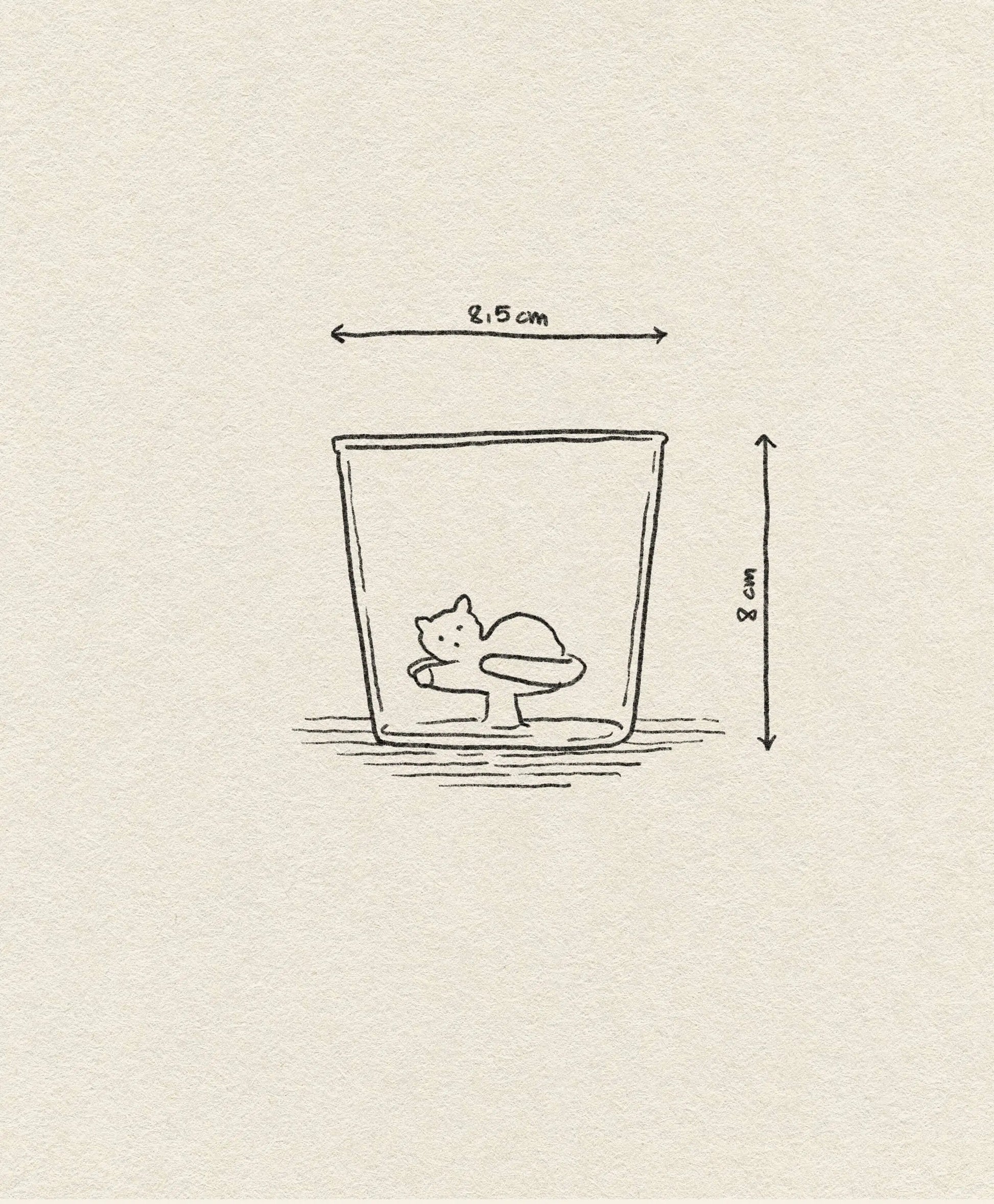 The Ichendorf Milano Tabby Cat Tumbler features a simple line drawing of a cat curled inside a glass. This handcrafted 8 cm tall, 8.5 cm wide tumbler includes labeled measurement lines beside and above the glass.