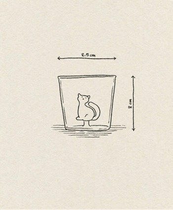 A minimalist line drawing of the Ichendorf Milano Tabby Cat Tumbler by Ichendorf Milano features a small cat inside a glass (8 cm tall, 8.5 cm wide at the top) on a textured beige background.