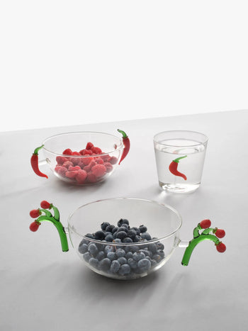Two hand-blown glass bowls of blueberries and raspberries with chili pepper and tomato handles from Ichendorf Milanos Vegetables collection sit beside an Ichendorf Milano Vegetables Tumbler on a white background.