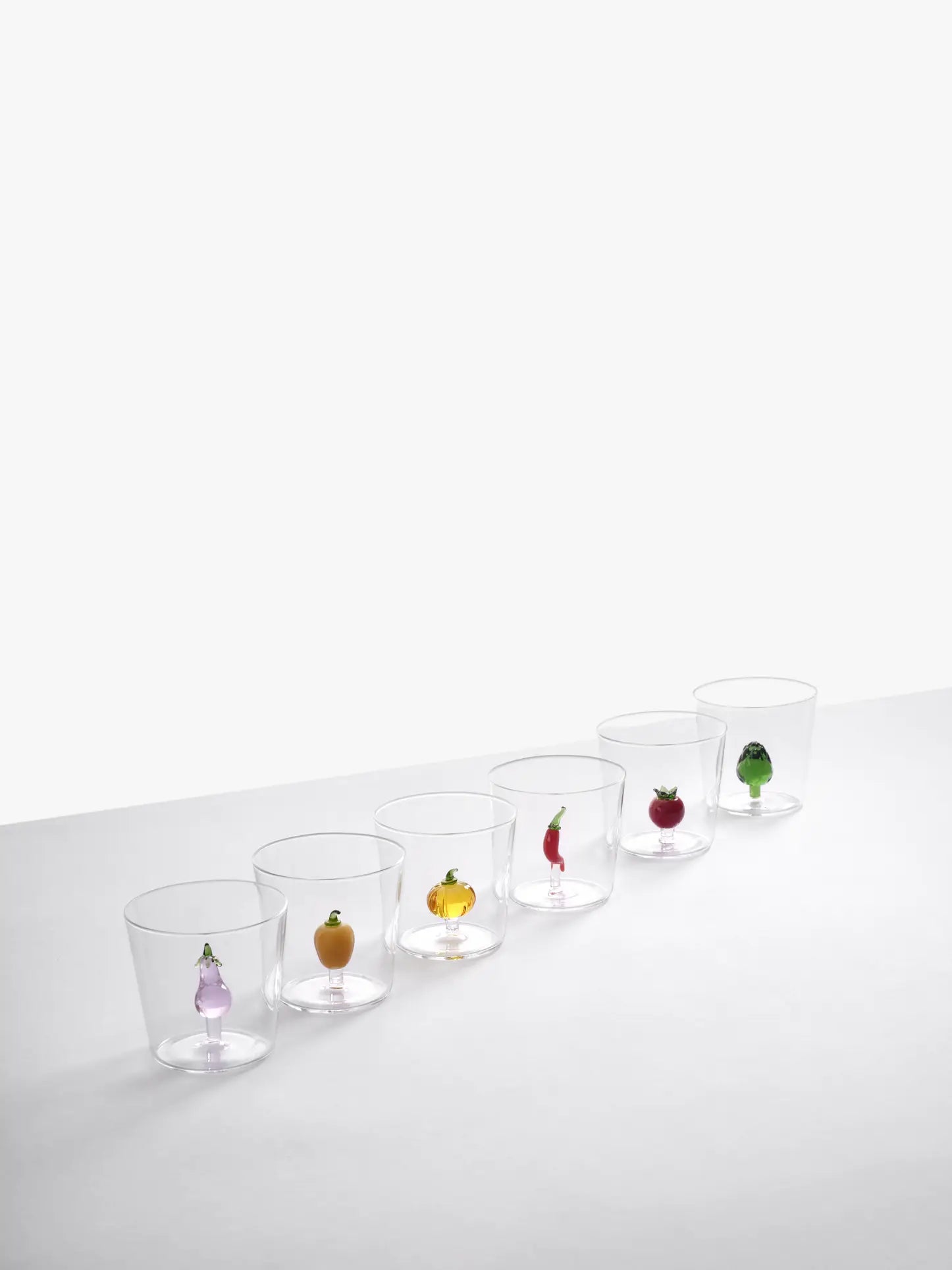 Six Ichendorf Milano Vegetables Tumblers, each with a handcrafted glass vegetable—eggplant, orange, pumpkin, chili pepper, tomato, or green bell pepper—adorn these unique collectibles by Ichendorf Milano.