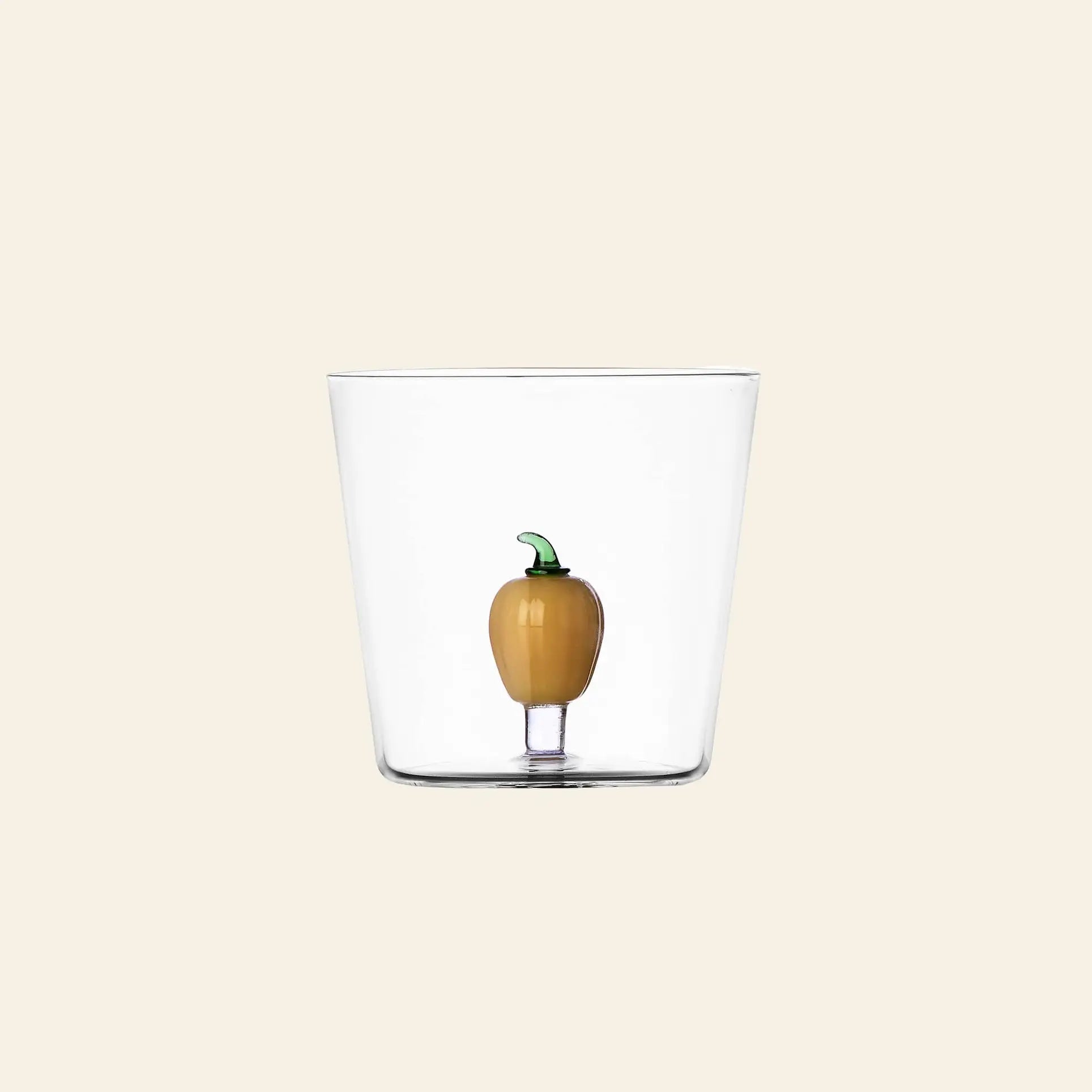 The Ichendorf Milano Vegetables Tumbler by Ichendorf Milano features a small yellow pepper figurine at its base—a unique handcrafted glass cup from the Vegetables collection, shown here on a plain beige background.