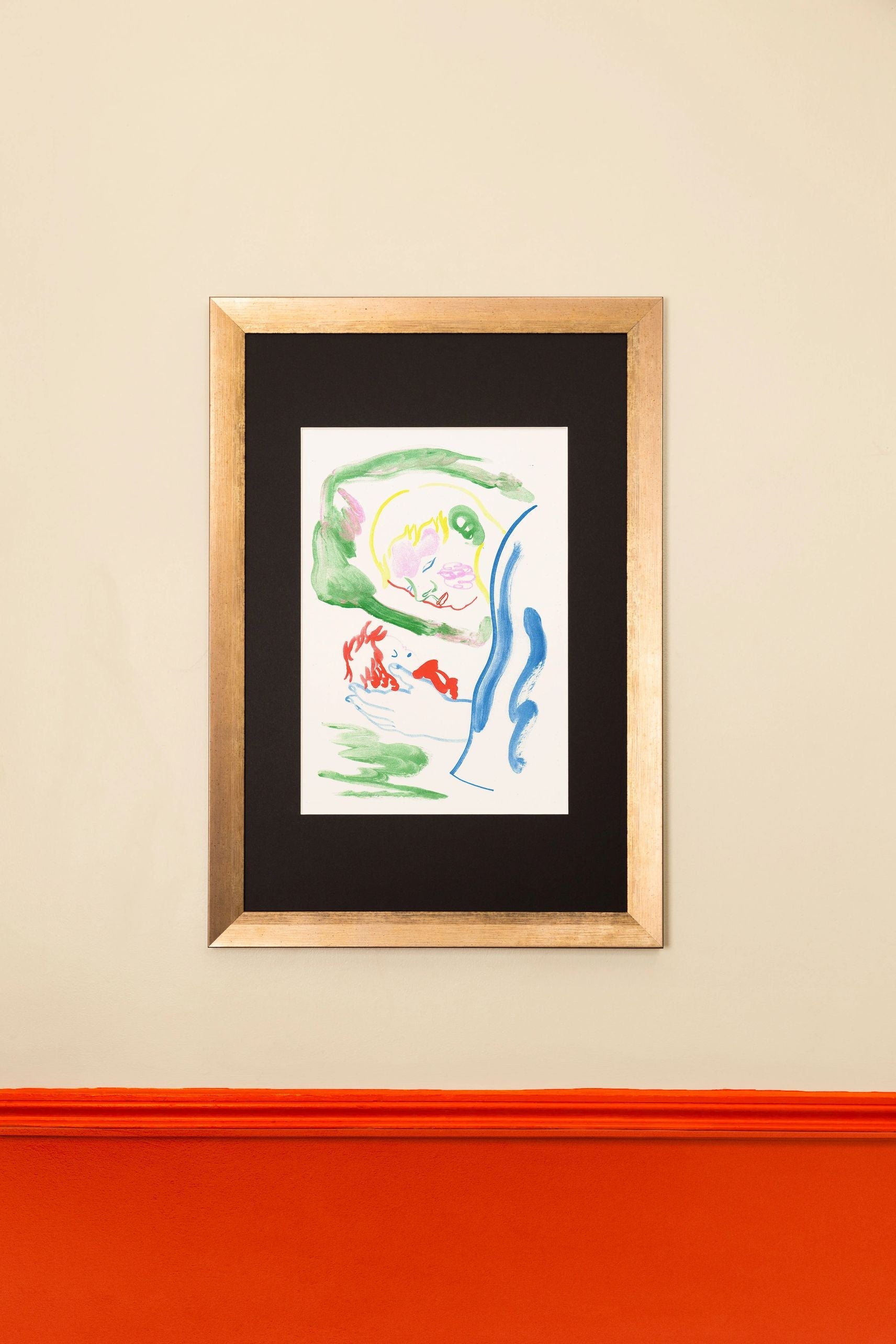 A framed limited edition KIBLIND Atelier Gaelle Loth - Ponyo on the Cliff print by KIBLIND Atelier with colorful brushstrokes hangs on a beige wall above red-orange wainscoting.