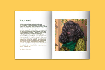 The KIBLIND Atelier Picture Book - Hair by KIBLIND Atelier is a pocket-sized book with French text titled BRUSHING on the left page and bold illustrations of a thickly haired person in a green sweater on the right, set against yellow.