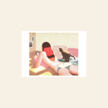A person lies on their stomach on a bed, looking at their phone as a black cat walks by. The softly lit scene recalls the textured risography style of KIBLIND Atelier Saho Wajimaya - Just Out Of The Bath.