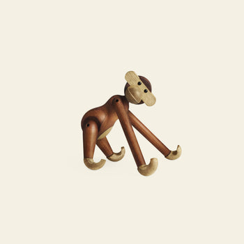 The Kay Bojesen Monkey Small by Kay Bojesen is a timeless wooden figurine with movable limbs in contrasting light and dark wood, shown standing on all fours against a plain, light background.